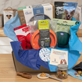 Dog product box with various pet accessories on a wooden surface